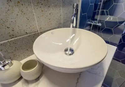 a white sink in a bathroom with water pouring into it at Vakakis Family Luxury Studios 2 in Palaiochóra
