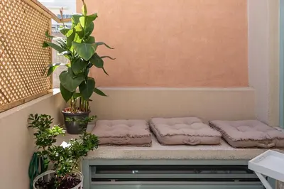 a bench with pillows and plants on a balcony at Mythodea Luxury Suites in Chania Town