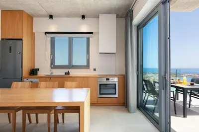 a kitchen with a table and a dining room at Krystallon Villas in Palaiochóra