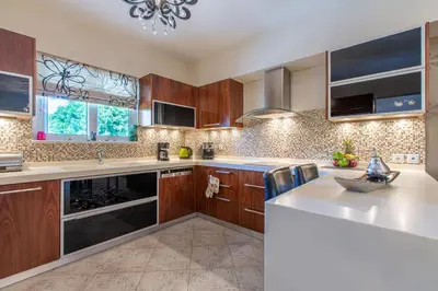 a kitchen with wooden cabinets and a white counter top at Elena Apartment in Chania Town