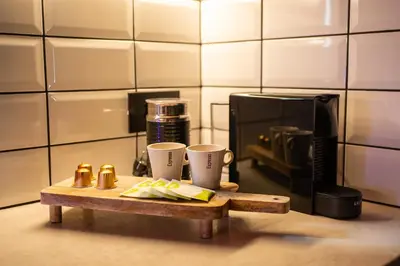 a coffee table with two cups and a microwave at Mimosa Urban Habitation in Chania Town