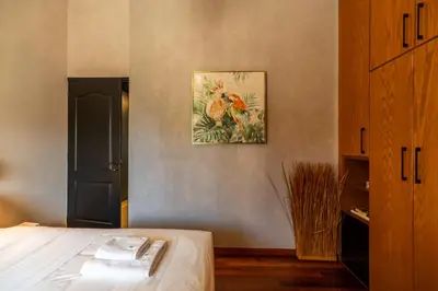 a bedroom with a bed and a painting on the wall at Mimosa Urban Habitation in Chania Town