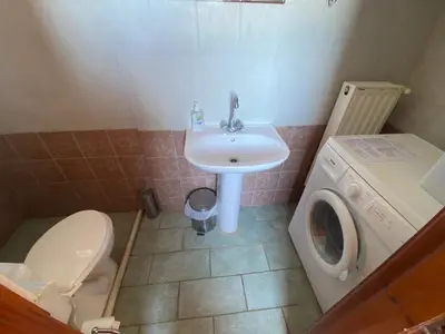a bathroom with a sink and a washing machine at Dusk Apartments with Stunning Mountain View in Chania Town