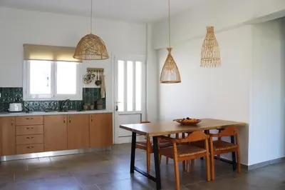 a kitchen with a wooden table and chairs and lights at Cassandra's Haven in Kissamos