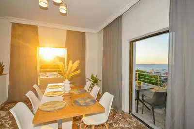 a dining room with a table and a view of the ocean at Blue Horizon Kisamos Deluxe Apartment in Kissamos