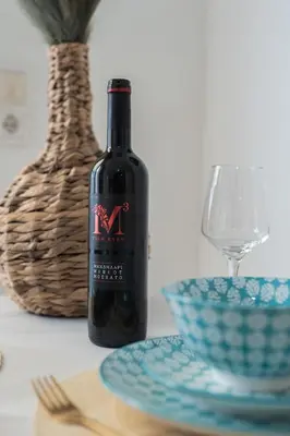 a bottle of wine sitting on a table next to a bowl at MYRTIA APARTMENT few steps from the sea in Chania Town