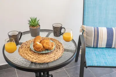 a table with a plate of bread and two glasses of orange juice at MYRTIA APARTMENT few steps from the sea in Chania Town