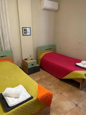 two beds in a room with yellow and red at VILLA BLUE VEDERE in Gerani Chanion