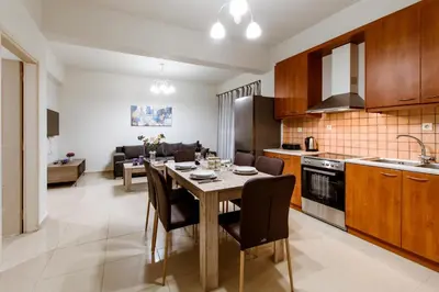 a kitchen and dining room with a table and chairs at OLIVE TREE in Galatás