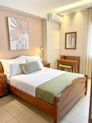 a bedroom with a large bed and a desk at Vista Mare in Palaiochóra