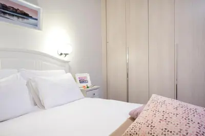 a bedroom with a white bed with a pink blanket at Casa Del Porto in Chania Town