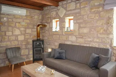 a living room with a couch and a stone wall at SundayMar Stone House in Chania Town