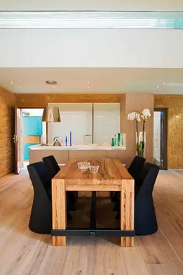 a dining room with a wooden table and black chairs at Conte Marino Villas in Maleme