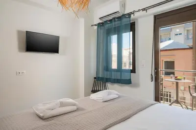 a bedroom with a bed and a television and a window at Crescendo City House in Chania Town