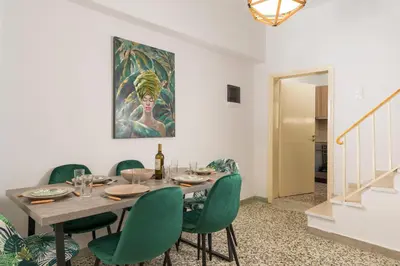 a dining room with a table and green chairs at Crescendo City House in Chania Town