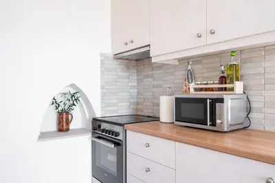 a kitchen with a microwave and a stove at Manos Home in Spiliá