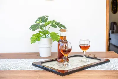 a bottle of wine and two glasses on a tray at Manos Home in Spiliá