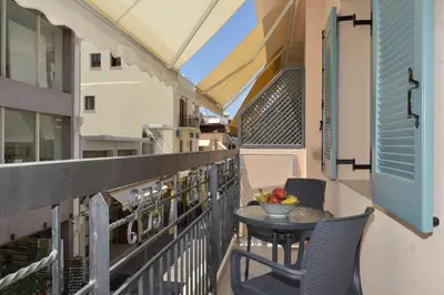 a balcony with a table and chairs and a bowl of fruit at Amara Porto Living in Chania Town