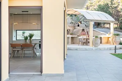 an open door to a patio with a table and a kitchen at Mondethea vantage point home in Chania Town