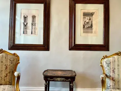two chairs and a stool in a room with two pictures at Thirty8 Heritage House in Chania Town