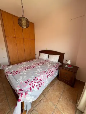 a bedroom with a bed and a wooden headboard and a table at CENTRAL HUGE LUXURY APARTMENT and FREE PARKING in Chania Town