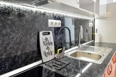 a kitchen with a sink and a cell phone on the counter at Rubini City Apartment in Chania Town