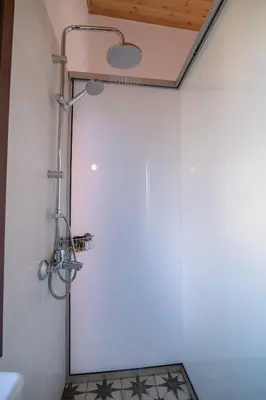 a shower in a bathroom with a white wall at Marthas DeLight Rooms in Chania Town