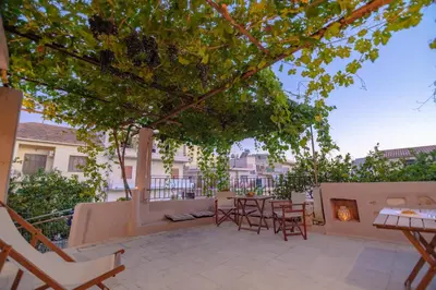 a patio with a table and chairs and a fireplace at Marthas DeLight Rooms in Chania Town
