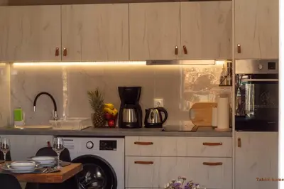 a kitchen with white cabinets and a counter top at Tabak home Sea side apartment in Chania Town