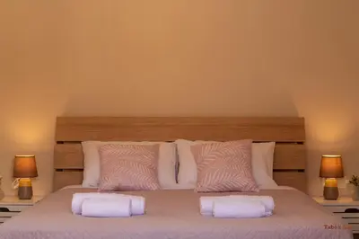 a bedroom with a large bed with two pillows at Tabak home Sea side apartment in Chania Town