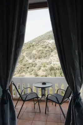a table and chairs on a balcony with a view at Lefteris Rooms in Kámbos