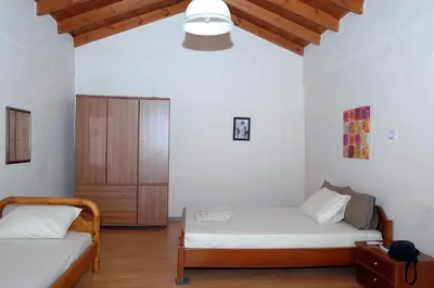 a bedroom with two beds and a wooden cabinet at Ioannis Home at Skonizo in Chania Town