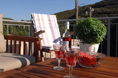 a bottle of wine and two glasses on a wooden table at Ioannis Home at Skonizo in Chania Town