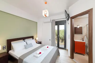 a bedroom with a bed with two red candles on it at Villa Gianta in Kissamos