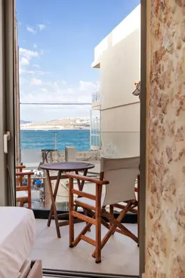 a balcony with a table and chairs and the ocean at La 'belle Luxury House Chania in Chania Town