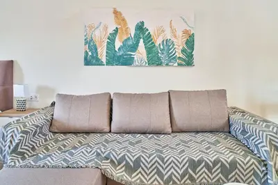 a couch in a living room with a painting on the wall at Bella Apartment in Kissamos