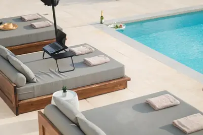 a pool with chaise lounges next to a swimming pool at Tholaria Villa in Chania Town