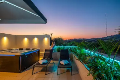 a patio with a hot tub and two chairs at Delight Luxury Residences - Souda in Souda
