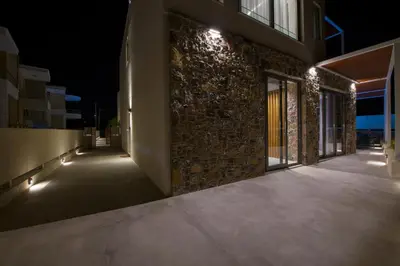 an empty hallway of a building at night with lights at Xenias Luxury Villas Kalathas in Kalathas