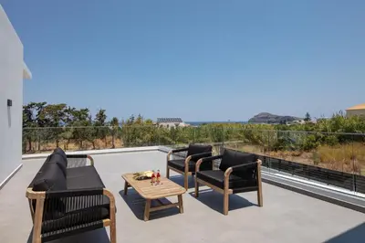 a patio with furniture and a view of the ocean at Horizon Luxury Villa in Chania Town