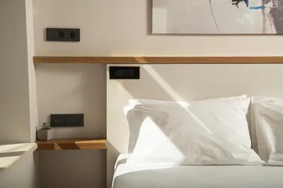 a bedroom with a white bed with a wooden headboard at Ontas IK18 in Chania Town