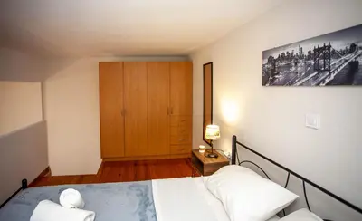 a bedroom with a bed and a wooden cabinet at Unique Apartment in Chania Town