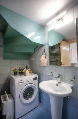 a bathroom with a washing machine and a sink at Unique Apartment in Chania Town