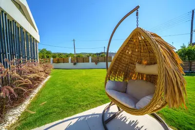 a wicker swing hanging in a yard at Villa Olira in Alikianós