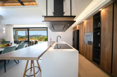a kitchen with a long island with a sink and a table at Villa Olira in Alikianós