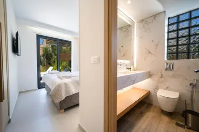 a bathroom with a bed and a sink and a mirror at Villa Olira in Alikianós