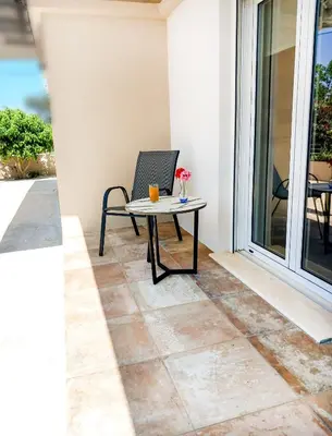 a patio with a table and a chair on a porch at Yucca Studio, beautiful apartment with garden in Ropanianá