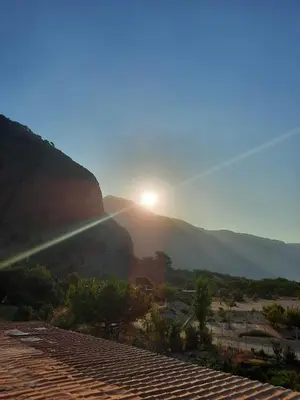 a view of the sun setting on a mountain at Paradise in Agia Roumeli