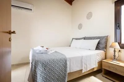 a bedroom with a bed with a blanket on it at Villa Mari Chania, with private ecologic pool and amazing view! in Chania Town
