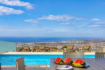 a table with a tray of fruit on top of a balcony at Villa Mari Chania, with private ecologic pool and amazing view! in Chania Town